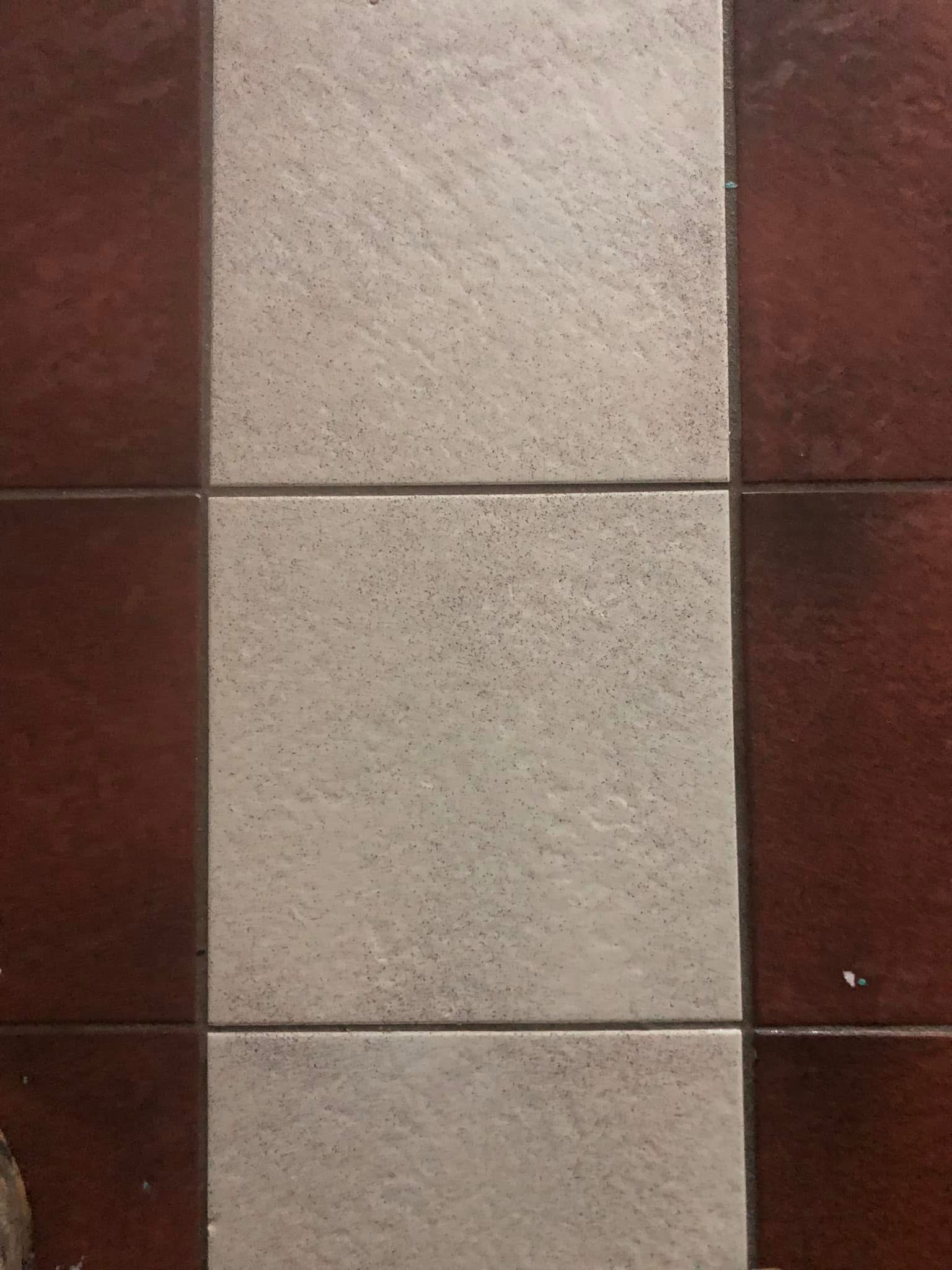 Detail van de rood-witte tegelvloer bij de bakkerij na reiniging