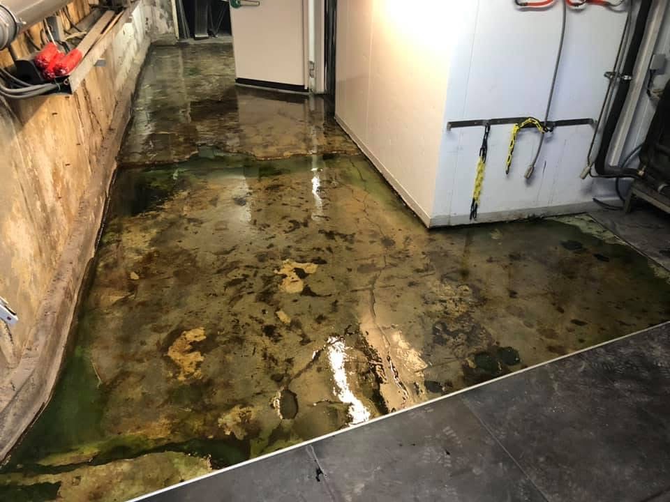 Bestaande keldervloer in Amsterdam vóór renovatie, met zichtbare vochtsporen