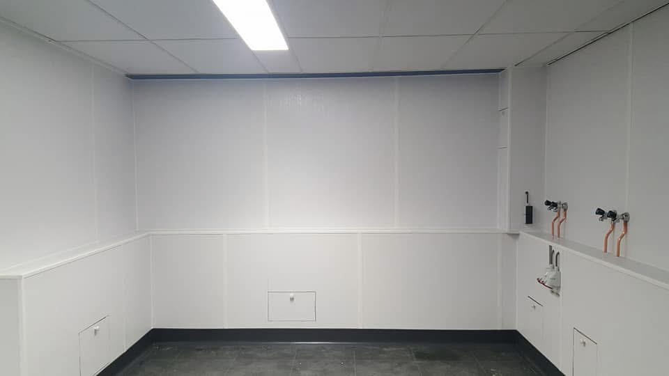 Gemonteerde witte Wonderboard HACCP-wandpanelen in een professionele ruimte
